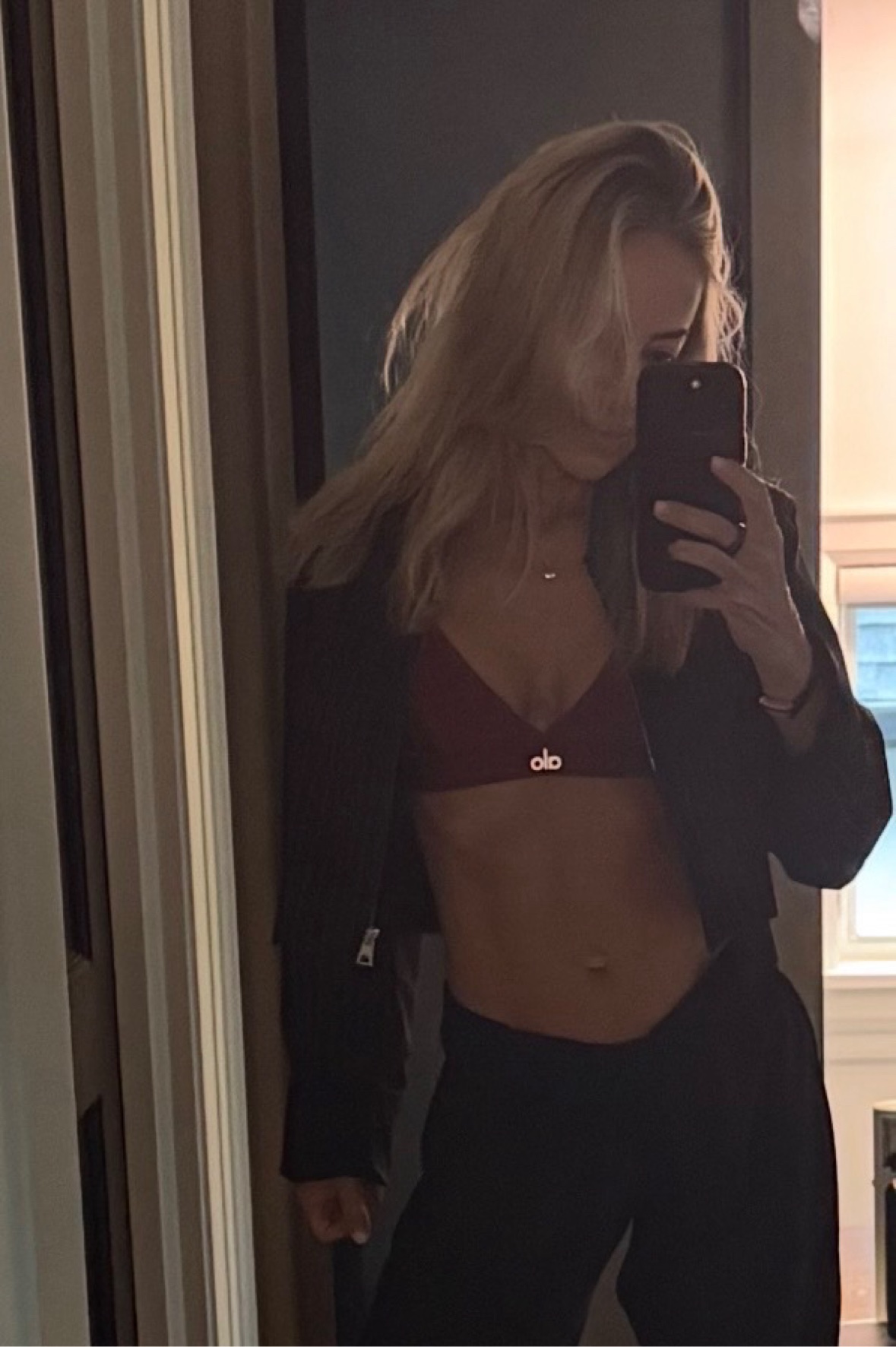 Pilates instructor taking a mirror photo in workout clothing